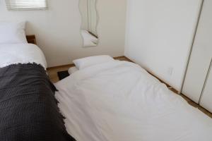 東京にあるThe Apartment Hotel 恵比寿1のベッド2台と鏡のある小さな部屋