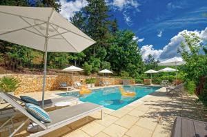 ein Swimmingpool mit Stühlen und einem Sonnenschirm in der Unterkunft La Tour de Cause in Castelnaud-la-Chapelle
