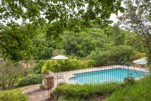 una piscina con ombrellone in giardino di La Tour de Cause a Castelnaud-la-Chapelle