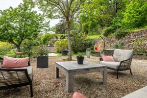 eine Terrasse mit 2 Stühlen, einem Tisch und einer Bank in der Unterkunft La Tour de Cause in Castelnaud-la-Chapelle + 8 Fotos