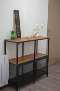 ein Regal mit einem Schild darüber in der Unterkunft Appartement avec 2 chambres Jardin privé parking gratuit in Clermont-Ferrand + 1 Foto