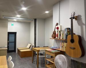 a guitar is hanging on a wall in a room at DONGMEN 3 Hostel in Taipei