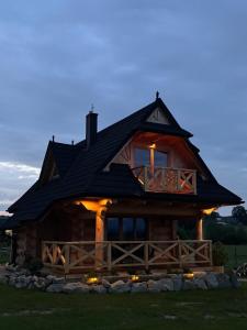 a large log cabin with a dark roof at Domek z Sercem in Pieniążkowice