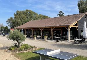 a pavilion with a table in front of a building at Camping Papillon Kinrooi - Vakantiehuis Familie 6P in Kinrooi