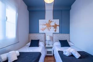 two beds in a room with blue walls at ON Family Playa de Doñana in Matalascañas +49 photos