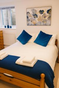 a bedroom with a bed with blue pillows at The Little Nest in Colchester in Colchester