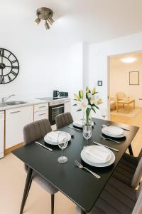 a black dining room table with chairs and a kitchen at The Little Nest in Colchester in Colchester