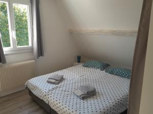 une chambre avec un lit avec deux serviettes dessus dans l'établissement Les Tilleuls, à Prayssac