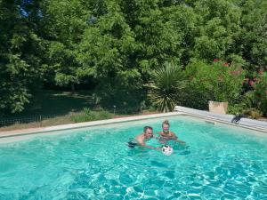 2 personnes jouant avec un ballon de football dans une piscine dans l'établissement Les Tilleuls, à Prayssac