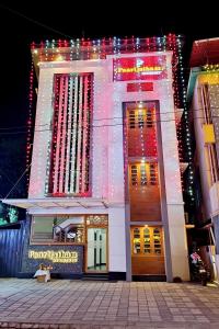 a lit up building with christmas lights on it at Paarijatham Residency in Guruvāyūr