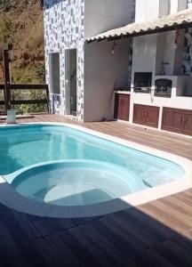 ein großer Swimmingpool in einem Hinterhof mit einem Haus in der Unterkunft Casa Blanca - Casa na Serra in Piraí
