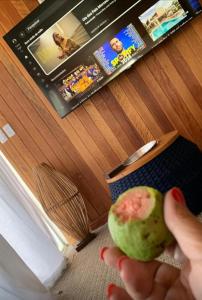 Eine Person, die einen Apfel vor einem Buch hält in der Unterkunft Casa Blanca - Casa na Serra in Piraí