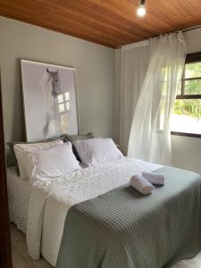 ein Schlafzimmer mit einem Bett mit zwei Handtüchern darauf in der Unterkunft Casa Blanca - Casa na Serra in Piraí