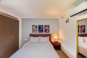 a bedroom with a large white bed and a mirror at A25 Hotel - 251 Hai Bà Trưng HCM in Ho Chi Minh City
