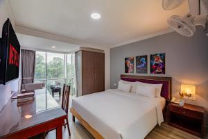 a bedroom with a bed and a desk and a television at A25 Hotel - 251 Hai Bà Trưng HCM in Ho Chi Minh City