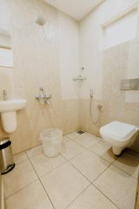 a bathroom with a toilet and a sink at Paarijatham Residency in Guruvāyūr