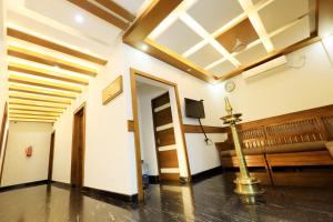 a room with a couch and a clock on the wall at Paarijatham Residency in Guruvāyūr +25 photos