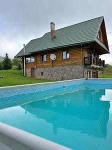 a large swimming pool in front of a house at Котедж ЛАТОРИЦЯ in Laterka