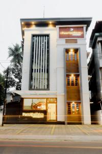 a large white building with a door in front at Paarijatham Residency in Guruvāyūr