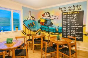 a restaurant with tables and a mural on the wall at The Stykkishólmur Inn by Ourhotels in Stykkishólmur