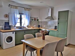 una cocina con armarios verdes y una mesa con sillas en Recanto do Ti Ze II, en Aldeia do Mato