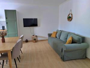 Una sala de estar con un sofá azul y una mesa. en Recanto do Ti Ze II, en Aldeia do Mato