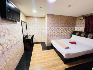 a bedroom with a bed and a tv on the wall at Kepong Business Hotel in Kuala Lumpur