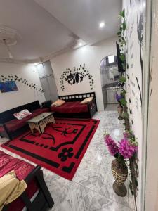 ein Wohnzimmer mit einem Bett und einem roten Teppich in der Unterkunft R feto house in Al Ḩārah al Kabīrah