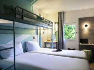 ein Schlafzimmer mit zwei Etagenbetten und einem Fenster in der Unterkunft ibis budget Marne la Vallée Chelles in Chelles + 43 Fotos