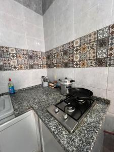 eine Küche mit einem Herd und einer Pfanne darauf in der Unterkunft R feto house in Al Ḩārah al Kabīrah + 2 Fotos