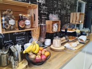 a counter with a bunch of food and fruit on it at Fasthôtel Clermont-Ferrand Gerzat in Gerzat