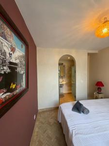 ein Schlafzimmer mit einem Bett und einem Gemälde an der Wand in der Unterkunft La Petite Maison - Dar El Bacha in Marrakesch