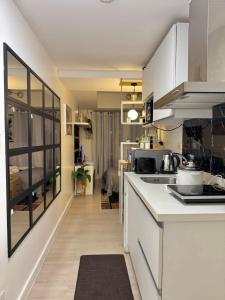 Una cocina con gabinetes blancos y encimera. en Staycation near Sucat Toll Gate, en Manila