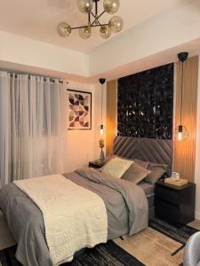 Un dormitorio con una cama grande y una lámpara de araña. en Staycation near Sucat Toll Gate, en Manila