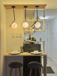 Una cocina con una mesa con dos taburetes y luces en Staycation near Sucat Toll Gate, en Manila