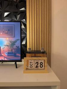 un reloj sentado en una mesa junto a una TV en Staycation near Sucat Toll Gate, en Manila
