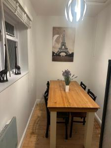 ein Esszimmer mit einem Holztisch und dem Eiffelturm in der Unterkunft 1a Woodlands Edge in Trowbridge