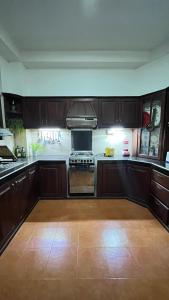 Una cocina con gabinetes de madera y un horno de estufa. en Mirewon Guest, en Weligama