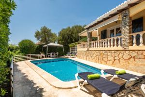 a villa with a swimming pool and a house at Villa Mari - con piscina privada y jardin en Calan Porter in Cala en Porter +38 photos