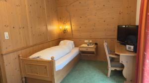 a room with a bed and a desk and a television at Hotel Sailer in Sankt Anton am Arlberg +52 photos