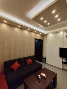 een woonkamer met een bank en een tafel bij Gentle Breeze Studio 3 in Amman