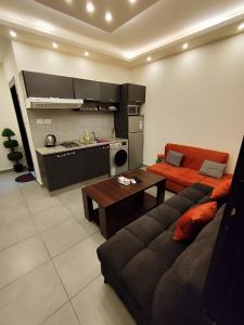 een woonkamer met een bank en een keuken bij Gentle Breeze Studio 3 in Amman