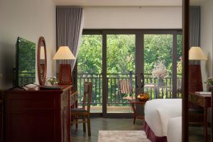 Un dormitorio con una cama y un balcón. en Sơn Nữ Emerald Hill Hotel, en Bak Kan