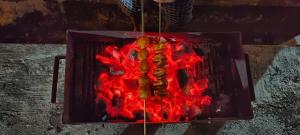 a person is standing next to a fire at The Malshej Mist in Ghātghar