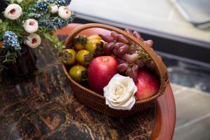 Una cesta de fruta sobre una mesa junto a un jarrón de flores en Sơn Nữ Emerald Hill Hotel, en Bak Kan 21 fotos más
