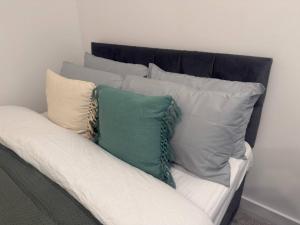 einen Haufen Kissen auf einer Couch in einem Zimmer in der Unterkunft Bradford Contractors, Long days Stays in Bradford