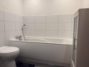 ein Badezimmer mit einer weißen Badewanne und einem WC in der Unterkunft Bradford Contractors, Long days Stays in Bradford