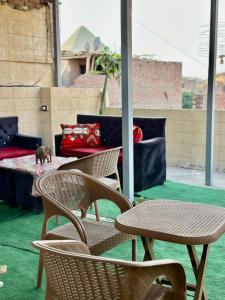 カイロにあるGreat Pyramids view Lodgeのパティオに置かれた椅子とテーブルの集まり