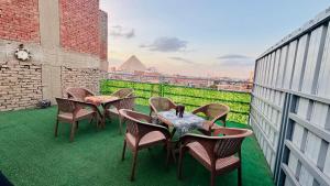カイロにあるGreat Pyramids view Lodgeのバルコニーに置かれたテーブルと椅子のグループ