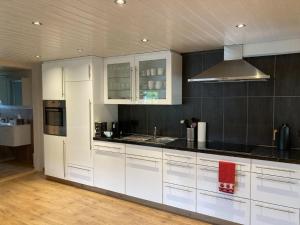 a kitchen with white cabinets and black counter tops at Im Toggi in Wattwil